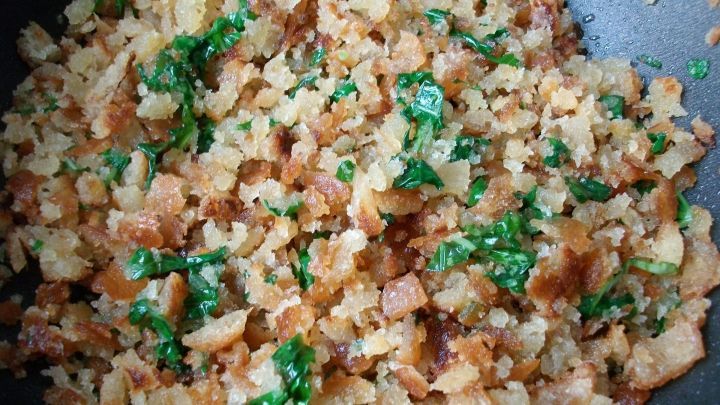 Krosse, goldene Cro&ucirc;tons mit frischem Basilikum liegen locker nebeneinander in einer Pfanne, bereit zum Servieren.