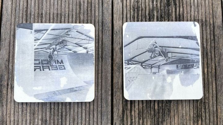 Zwei Holzplatten zeigen Fotos, die einen Skater beim Tricks im Skatepark festhalten, auf einem Holzuntergrund platziert.