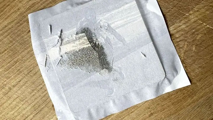 Das Papier wird mit einem nassen Schwamm durchtränkt und kann dann vorsichtig vom Holz abgerubbelt werden.
