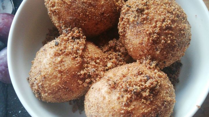 Saftige Zwetschgenkn&ouml;del mit Hefeteig liegen in einer Sch&uuml;ssel, umh&uuml;llt von einer knusprigen, s&uuml;&szlig;en Brotkruste.