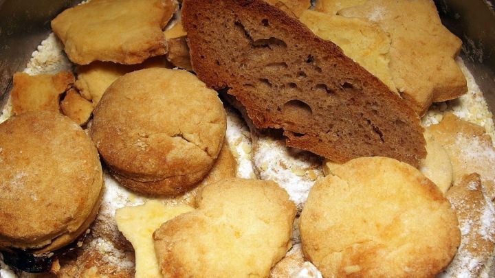 Pl&auml;tzchen liegen in einer Dose, weichgehalten durch eine Scheibe Brot in der Mitte. Die Umgebung ist mehlig best&auml;ubt.