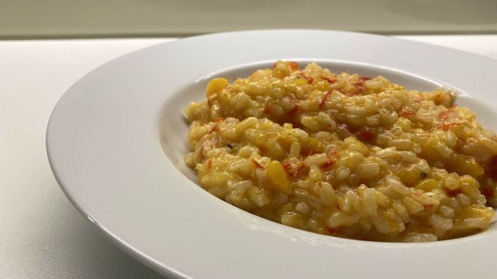 In einer wei&szlig;en Sch&uuml;ssel liegt cremiges K&uuml;rbisrisotto, das unwiderstehlich dampft und k&ouml;stlich aussieht.