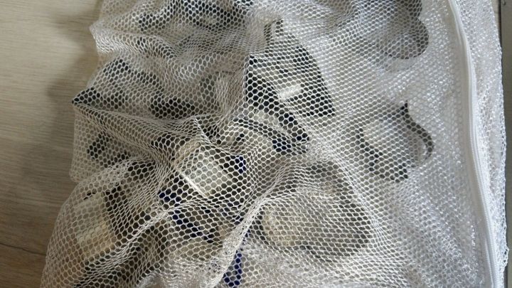 Eine durchsichtige Tasche enth&auml;lt mehrere Ausstechf&ouml;rmchen, die auf einem hellen Holztisch liegen.