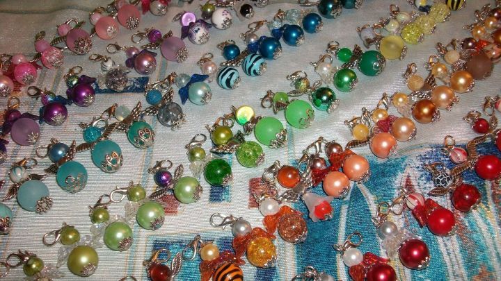 Bunte Schutzengelchen aus Perlen sind auf einem Tisch angeordnet und warten darauf, f&uuml;r DIY-Projekte verwendet zu werden.