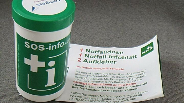 Eine gr&uuml;ne Notfalldose steht neben einem wei&szlig;en Infoblatt, das wichtige Informationen f&uuml;r Notfallsituationen auflistet.