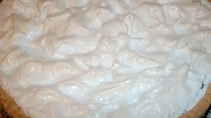 Das Baiser oben drauf verteilt und dann mit dem Gummischaber immer solche Zipfel oder Nasen aus dem Baiser hochgezogen.