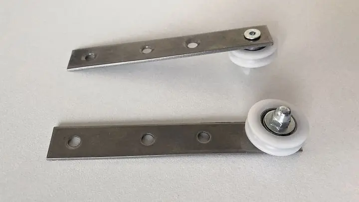 Die beiden Rollen - bereits an die Metallplatten geschraubt - vor der Montage an das Türblatt.