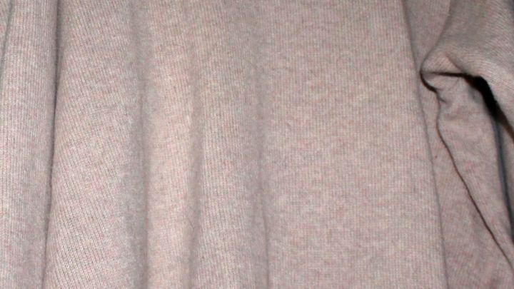 Ein Kleidungsst&uuml;ck mit einer leicht strukturierten Oberfl&auml;che, das sich in einem neutralen Raum befindet.