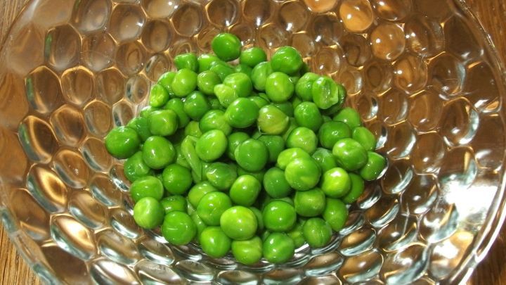 Gr&uuml;ne TK-Erbsen liegen in einer Sch&uuml;ssel und k&ouml;nnten als K&uuml;hlkompressen verwendet werden, um Schwellungen zu lindern.