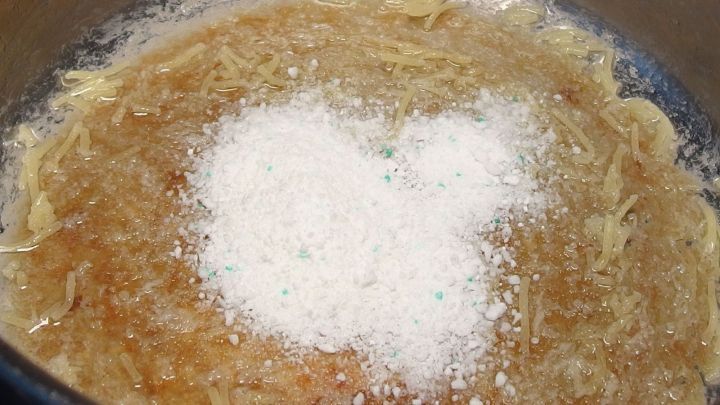 Ein gro&szlig;er Kochtopf mit angebranntem Inhalt zeigt Salz, das zum Entfernen von Angebranntem verwendet wird.