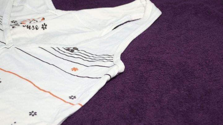 Ein Kleidungsst&uuml;ck mit auff&auml;lligem Muster liegt auf einem lila Handtuch, bereit, gegen Achselschwei&szlig; eingesetzt zu werden.