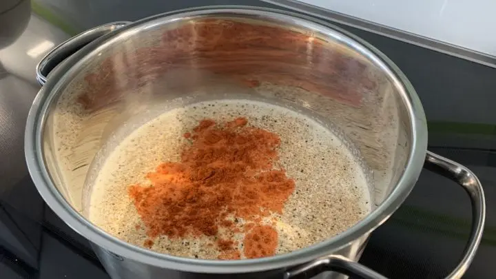 Zu der Sahne-Milch-Mischung gibst du ca. 1,5 TL Salz und Pfeffer aus der Mühle. Ebenso das Paprikapulver, alles schön verrühren und abschmecken, evtl. nachwürzen.
