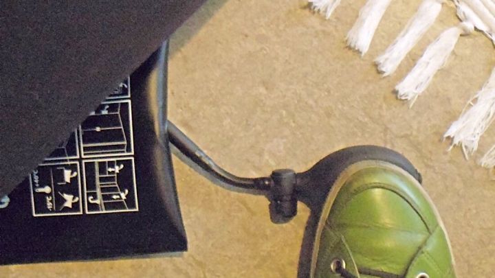 Ein Montagekissen wird mit einem Fu&szlig; bet&auml;tigt, um M&ouml;bel anzuheben. Der Untergrund ist ein heller Boden mit einem Teppich.