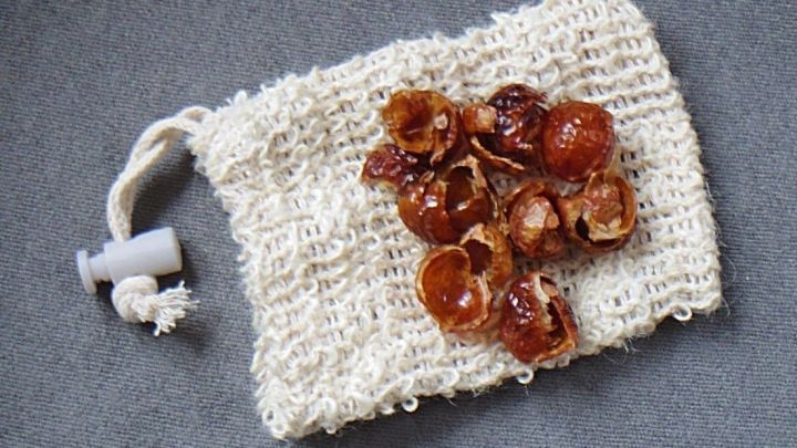 Waschn&uuml;sse liegen in einem kleinen Stoffbeutel, bereit zum nachhaltigen Waschen, auf einem grauen Hintergrund.