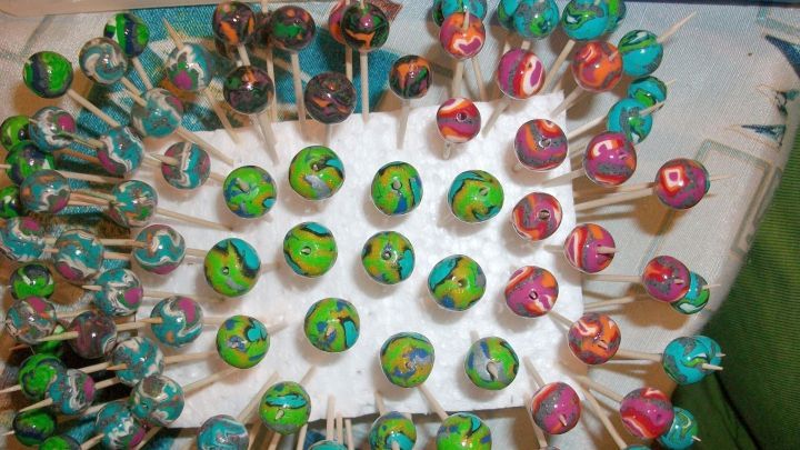 Bunte FIMO-Kugeln stehen auf einem Styropor-Brett, w&auml;hrend sie zum Schmuckherstellen vorbereitet werden.