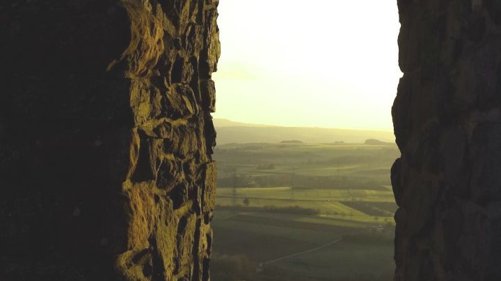 Durch einen steinernen Fensterrahmen sieht man eine weite, beruhigende Landschaft, die Hoffnung in schweren Zeiten symbolisiert.