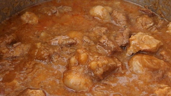 Gulasch kocht brodelnd in einem Topf, durchzogen von saftigen Fleischst&uuml;ckchen, in einer dicken, aromatischen Sauce.