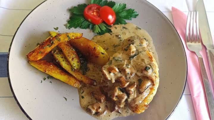 Zartes J&auml;gerkr&uuml;stchen in cremiger Sauce, begleitet von knusprigen, gebackenen Kartoffelspalten und frischen Tomaten.