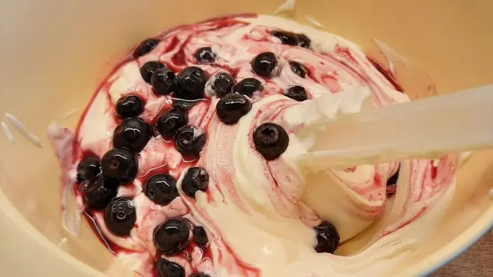Die geschlagene Sahne wird mit Schmand und Quark verrührt. Anschließend gibt man Heidelbeeren dazu.