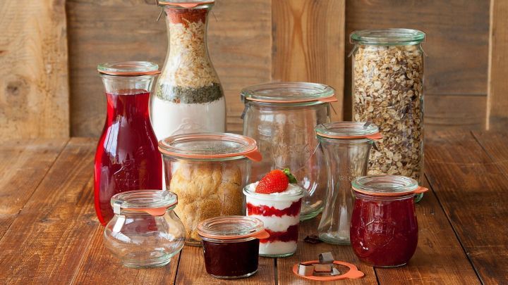 Gl&auml;ser mit eingelegten Lebensmitteln stehen ordentlich auf einem Holztisch, um frische Konservierung und Genuss zu zeigen.