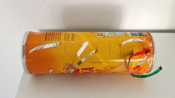 Ein runder Beh&auml;lter mit Geschenkband liegt auf einem Tisch, bereit zur Aufbewahrung von Geschenkband in einem hellen Raum.