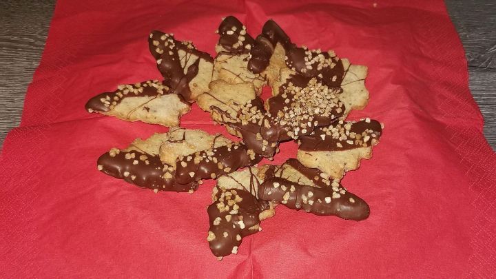 Tannenbaum-Pl&auml;tzchen aus Keksen, dekoriert mit Schokolade und N&uuml;ssen, liegen auf einer roten Serviette.