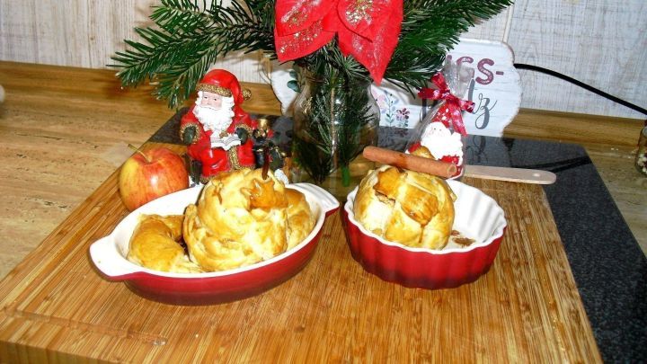 Herzhafte Bratbirnen und s&uuml;&szlig;e Brat&auml;pfel liegen dekorativ in roten Schalen, umgeben von Weihnachtsdekoration.