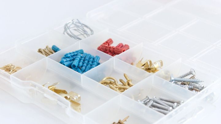 Eine Sortierkiste enth&auml;lt farbige Verbindungselemente und Schrauben, die ordentlich in F&auml;chern angeordnet sind.