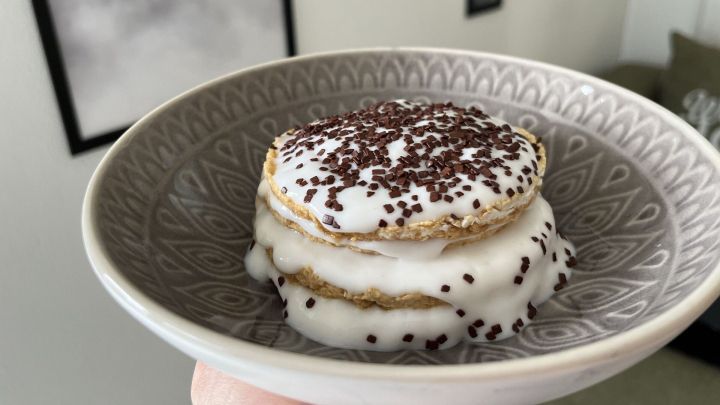 Ein gestapelt pr&auml;sentiertes Reiswaffel-Tiramisu mit schaumiger F&uuml;llung und Schokoladensprinkles in einem dekorativen Teller.
