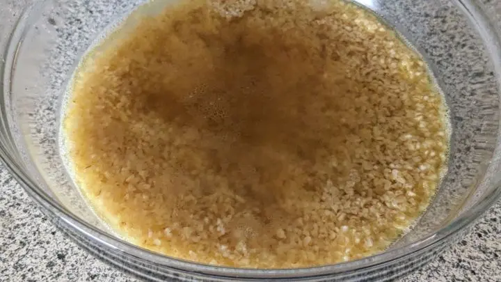 Abgewogenen Bulgur in eine Schüssel geben und mit kochendem Wasser übergießen, quellen lassen.