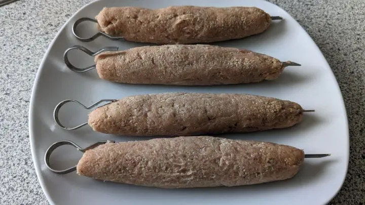 Nun die Kugeln nacheinander zu Rollen formen und mit Metall- oder Holzspießen bestücken.