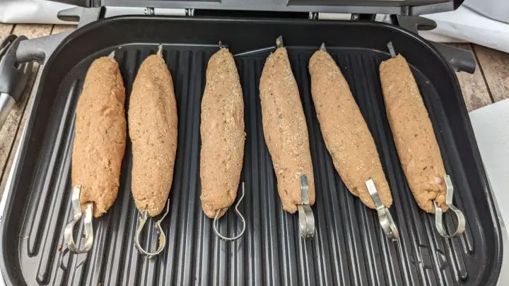 Elektrischen Outdoor Grill vorheizen. Wenn der Piepton erklingt, öffnen und Spieße hineinlegen.