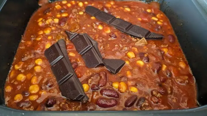 Schwarze Bohnen, Kidney-Bohnen, Gem&uuml;semais und die Schokoladenriegel hineingeben.