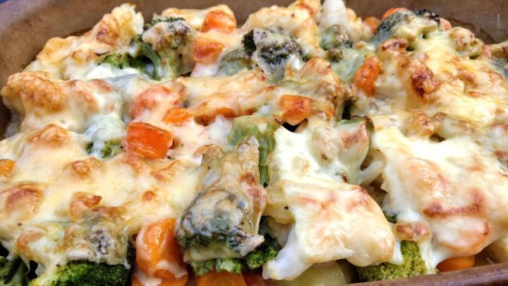 Ein k&ouml;stlicher Kartoffel-Blumenkohl-Brokkoli-Auflauf, goldbraun &uuml;berbacken, serviert in einer traditionellen Auflaufform.