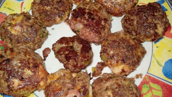 Auf einem bunten Teller liegen mehrere knusprige Rote Bete-Frikadellen, frisch zubereitet und appetitlich angerichtet.