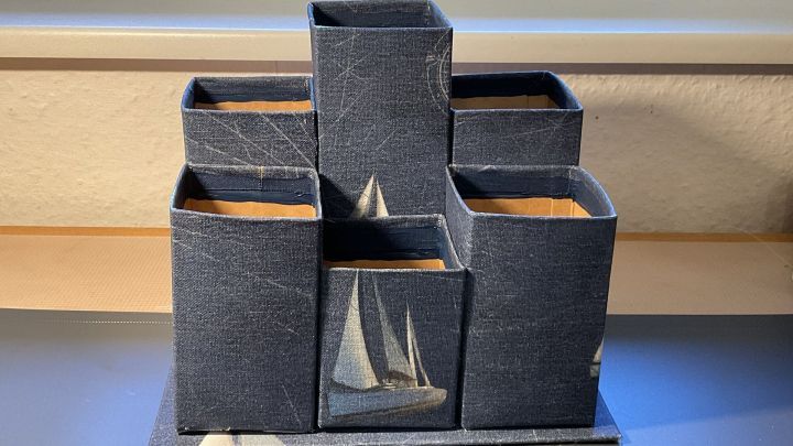 Ein stilvoller Organizer f&uuml;r Stifte aus blauem Material steht auf einem Tisch und bietet Platz f&uuml;r Utensilien.