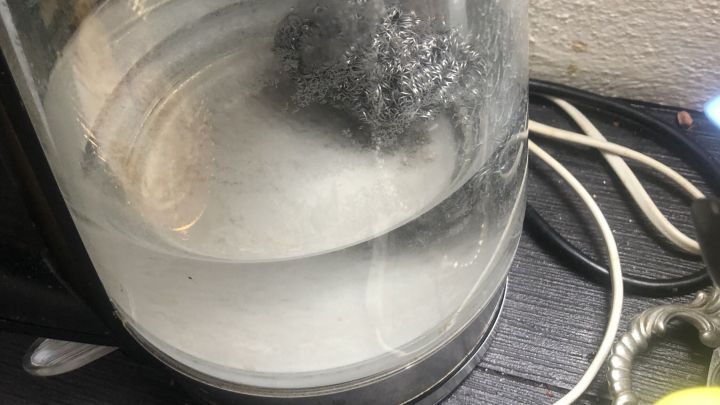 Ein Wasserkocher mit kochendem Wasser, in dem sich Eisenwolle befindet, um den Kalk zu entfernen.
