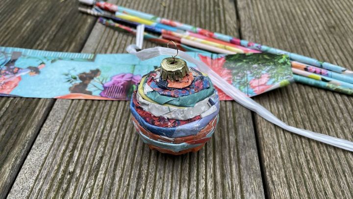 Kreative Vollendung: Ein dekoratives Band f&uuml;r die Aufh&auml;ngung rundet die selbstgemachte Papier-Weihnachtskugel perfekt ab.