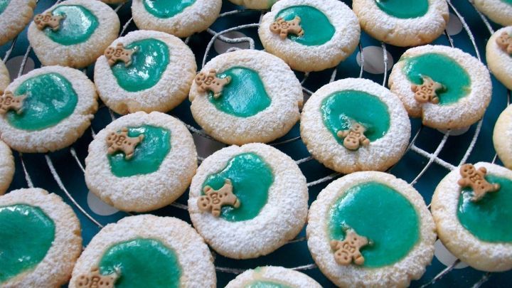 Kleine, runde Pl&auml;tzchen mit gr&uuml;nem Zuckerguss und Keksen in einem Gitter, die festlich f&uuml;r den Pool-Trend 2023 dekoriert sind.