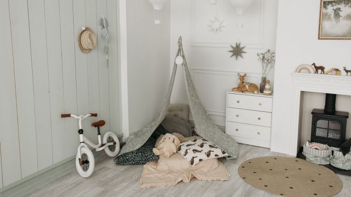 Ein waschbarer Teppich liegt auf dem Boden in einem gem&uuml;tlichen, hellen Kinderzimmer mit einem Spielzelt und Spielzeug.