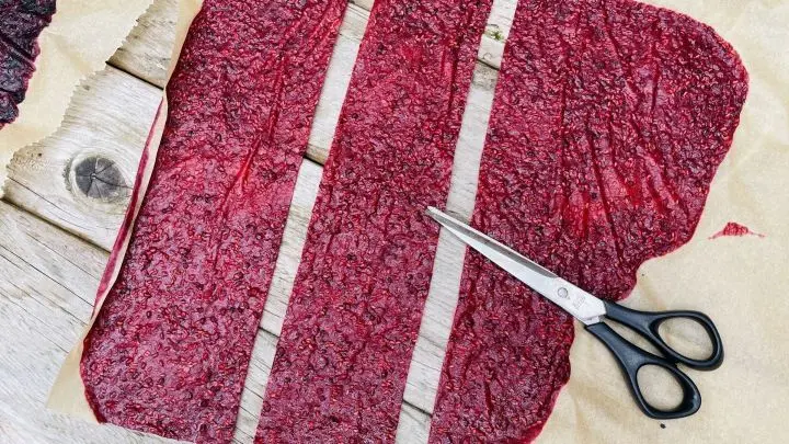 Das auf Backpapier getrocknete Fruchtleder wird in Streifen geschnitten.