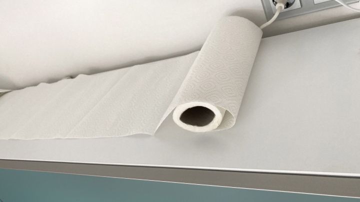 Ein Papiertuch liegt auf einem K&uuml;chenschrank, um Fett zu vermeiden, w&auml;hrend Steckdosen daneben sichtbar sind.