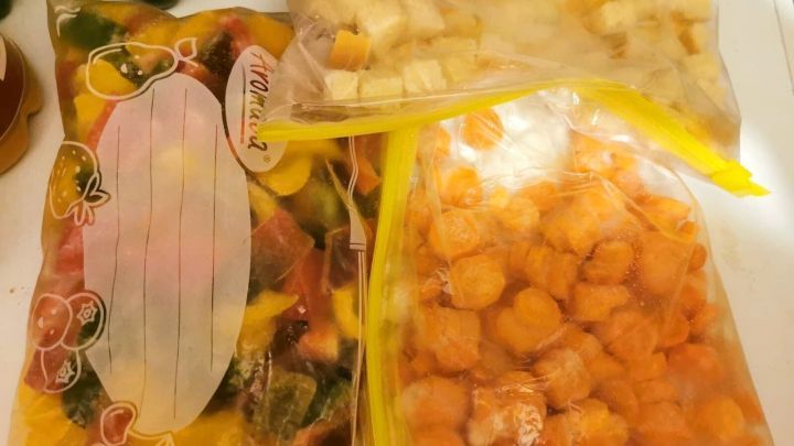 Gefrorenes Gem&uuml;se und Brot in beschrifteten T&uuml;ten sind ordentlich verstaut, um bei Lebensmitteln zu sparen und frisch zu bleiben.