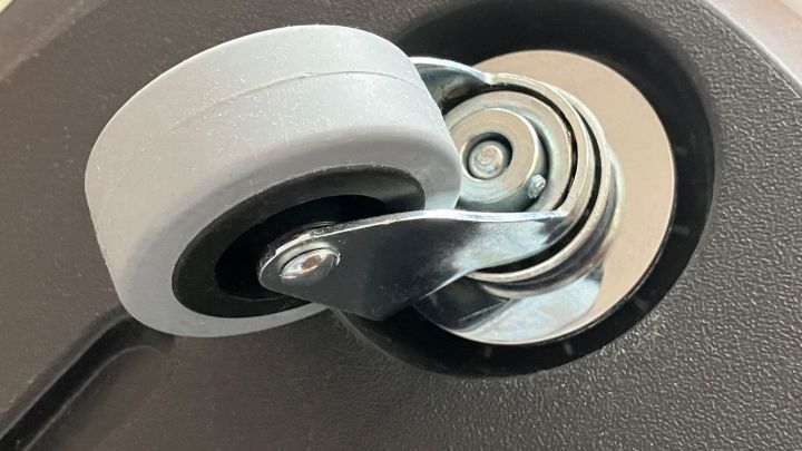 Ein graues Rad wird an einem Staubsauger gezeigt, der sich bewegt und die Nutzung erleichtert.