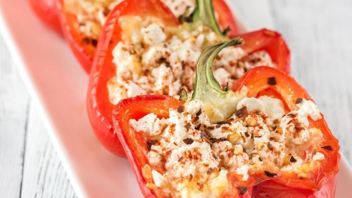 Gef&uuml;llte Paprika mit Zucchini und Schafsk&auml;se stehen appetitlich auf einem wei&szlig;en Teller und laden zum Genie&szlig;en ein.