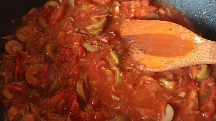 Eine dicke, tomatige Sauce wird mit Thunfisch und Oliven in einer Pfanne zubereitet, um Spaghetti "Amore" zu erg&auml;nzen.
