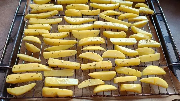 Macht ein wenig Arbeit, aber die Mühe lohnt: Die Pommes einzeln auf das obere Blech legen, so kann das Öl angtropfen.