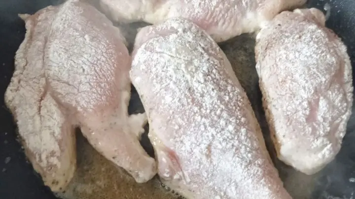 Die Hähnchenbrust-Filets werden gewürzt und in Mehl gewendet, bevor sie in Olivenöl gebraten werden.