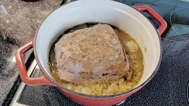 Die Unterseite mit Schweineschmalz kr&auml;ftig anbraten. Die grob geschnittenen Zwiebeln auf den Topfboden legen. Fleisch drauf legen.