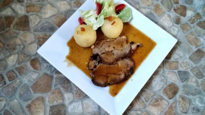 Schweinebraten mit Senfkruste und Bierso&szlig;e fertig bereit f&uuml;r den Tisch. Ein kleines Salatbouquet dazu und nat&uuml;rlich Kartoffelkn&ouml;del. 